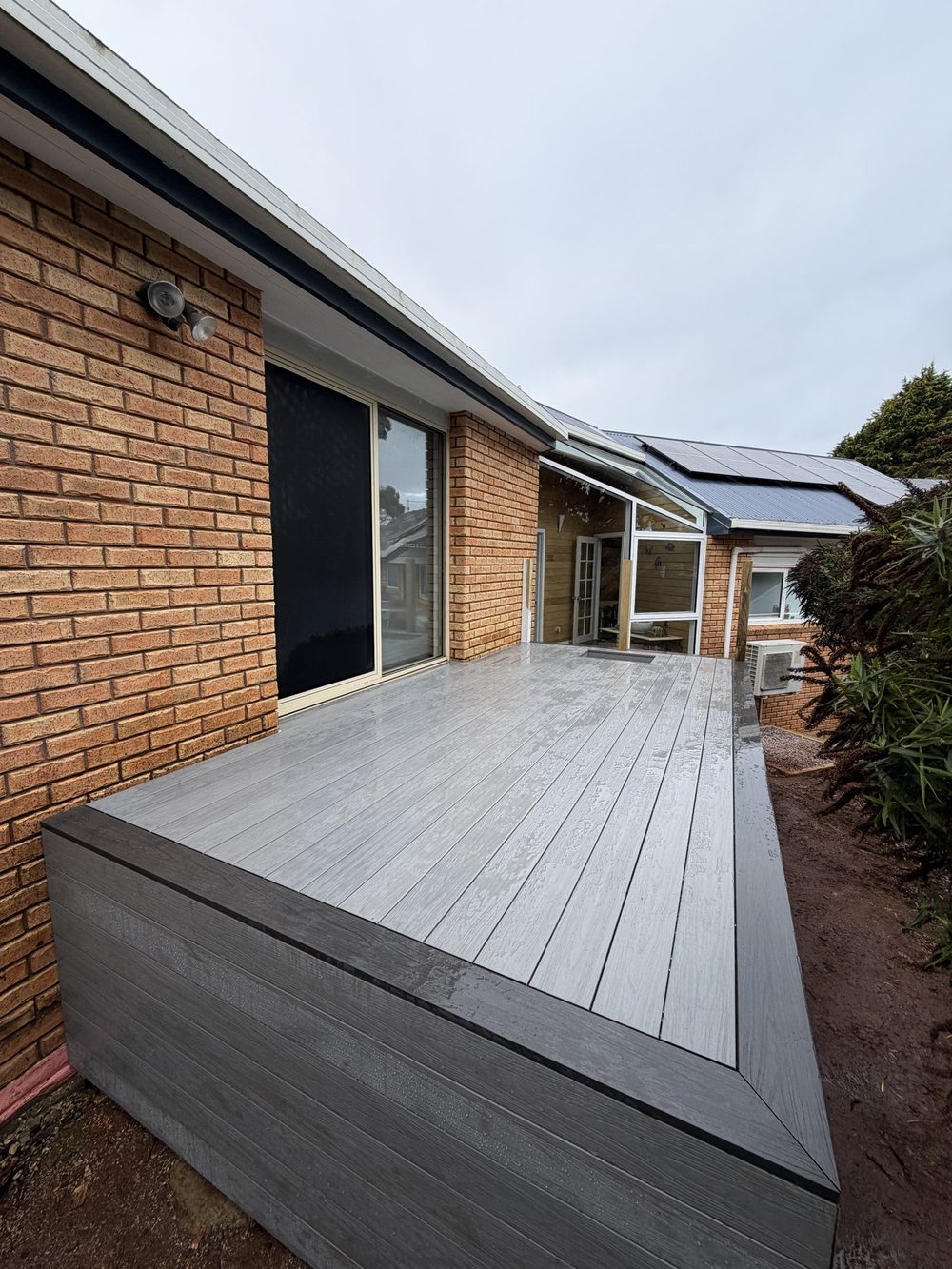 Composite decking against brick home